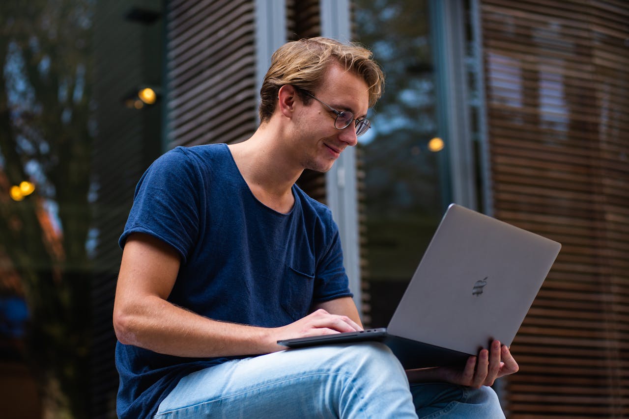 services-02 A young man sitting outdoors in Leiden, Netherlands, working on a laptop.